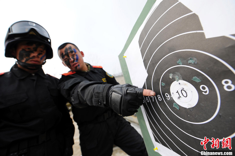 A sniper shares experience with another. In late January, snipers of the Armed Police detachment in Yantai of Shandong province conducted winter training. (Chinanews.com/ Sun Xiaofeng)