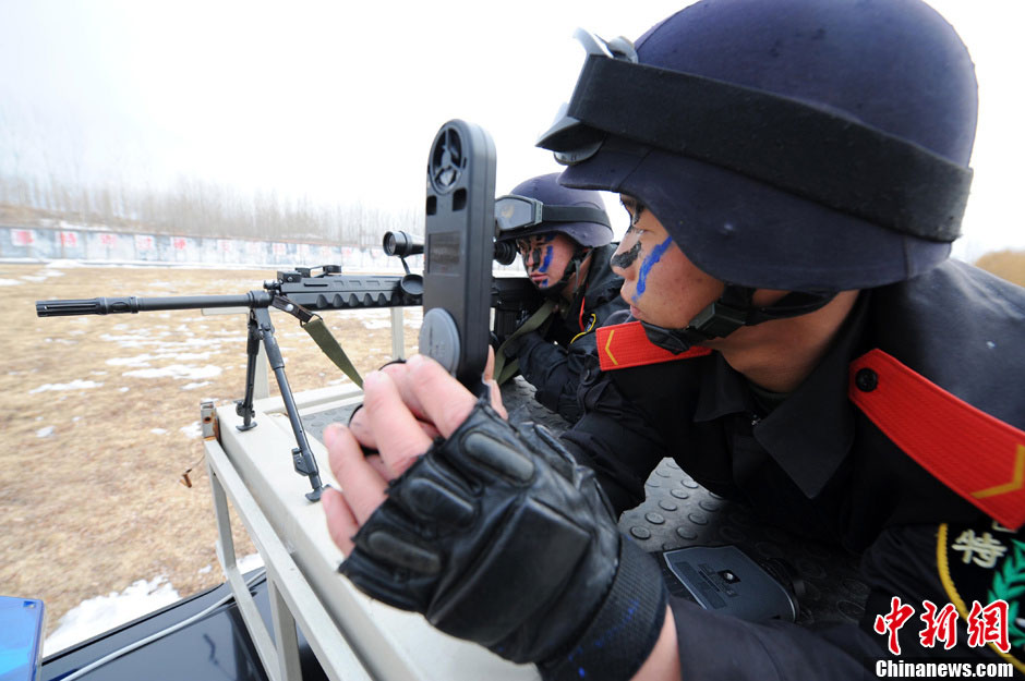 An assistant measures wind speed for the sniper. In late January, snipers of the Armed Police detachment in Yantai of Shandong province conducted winter training. (Chinanews.com/ Sun Xiaofeng)