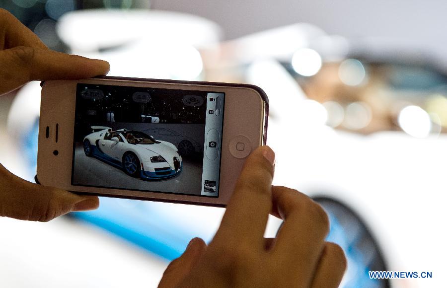 A visitor takes photo of a Bugatti Vitesse car during the 3rd Qatar International Auto Show held in Doha Exhibition Center, Qatar, on Jan. 28, 2013. The six-day Auto Show kicked off here on Monday. (Xinhua/Chen Shaojin)