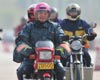 Migrant workers ride motorbikes on their way back home on the 321 National Highway.