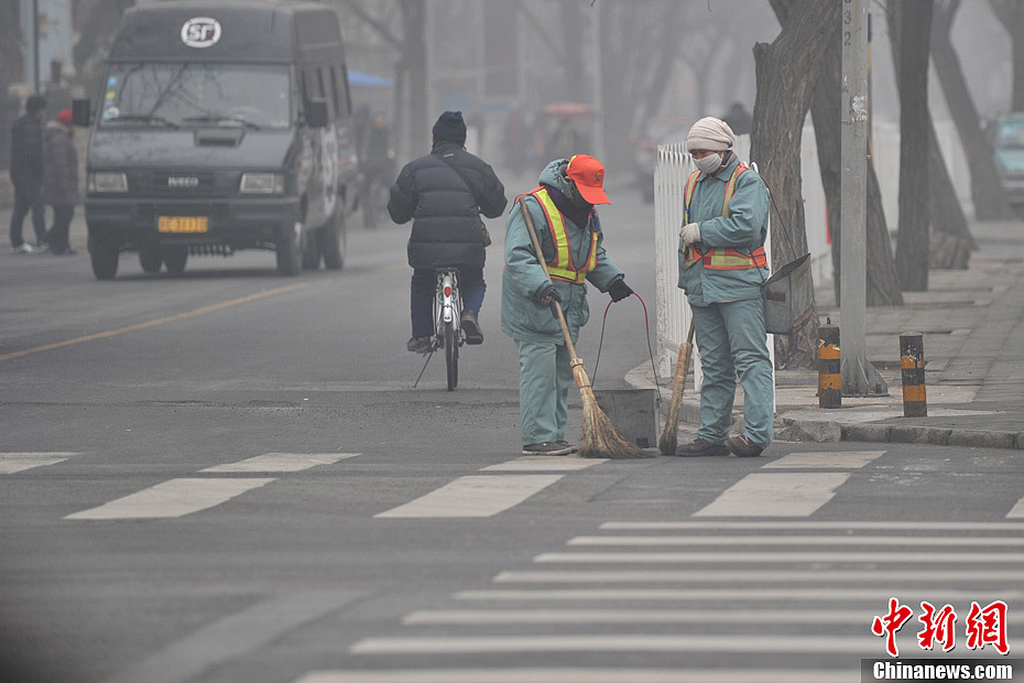 A photo taken on Jan. 29 shows two sanitation workers cleaning the smog-shrouded street. The fourth round of heavy smog in four weeks hit Beijing on Tuesday and led to serious air pollution, which has sent more people with respiratory illnesses to hospitals. However, a group of people had to stay on jobs outdoors. (Chinanews.com/Jin Shuo)