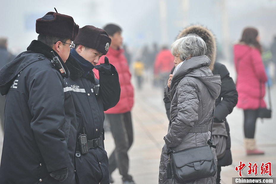 A photo taken on Jan. 29 shows two policemen on duty in the foggy weather. The fourth round of heavy smog in four weeks hit Beijing on Tuesday and led to serious air pollution, which has sent more people with respiratory illnesses to hospitals. However, a group of people had to stay on jobs outdoors. (Chinanews.com/Jin Shuo)