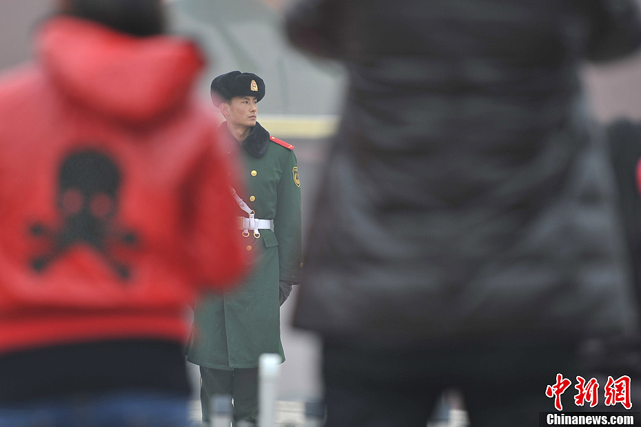 A photo taken on Jan. 29 shows a soldier on duty in the foggy weather. The fourth round of heavy smog in four weeks hit Beijing on Tuesday and led to serious air pollution, which has sent more people with respiratory illnesses to hospitals. However, a group of people had to stay on jobs outdoors. (Chinanews.com/Jin Shuo)