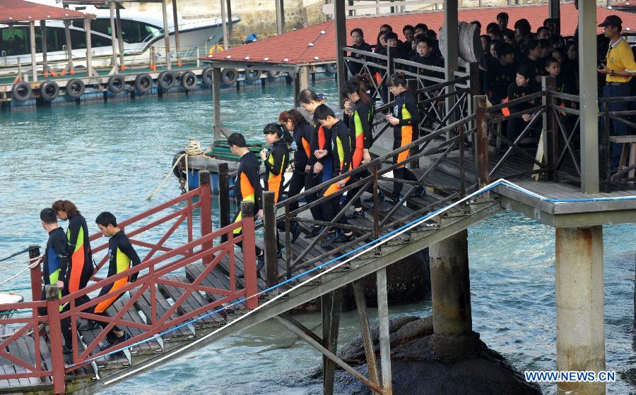 Tourists enjoy themselves at the Boundary Island scenic area in Lingshui Yi Autonomous County in south China's Hainan Province, Jan. 30, 2013. Hainan launched tourism promotion with the theme of fresh air, to attract visitors from northern China where heavy haze lingered recently. (Xinhua/Zhao Yingquan) 