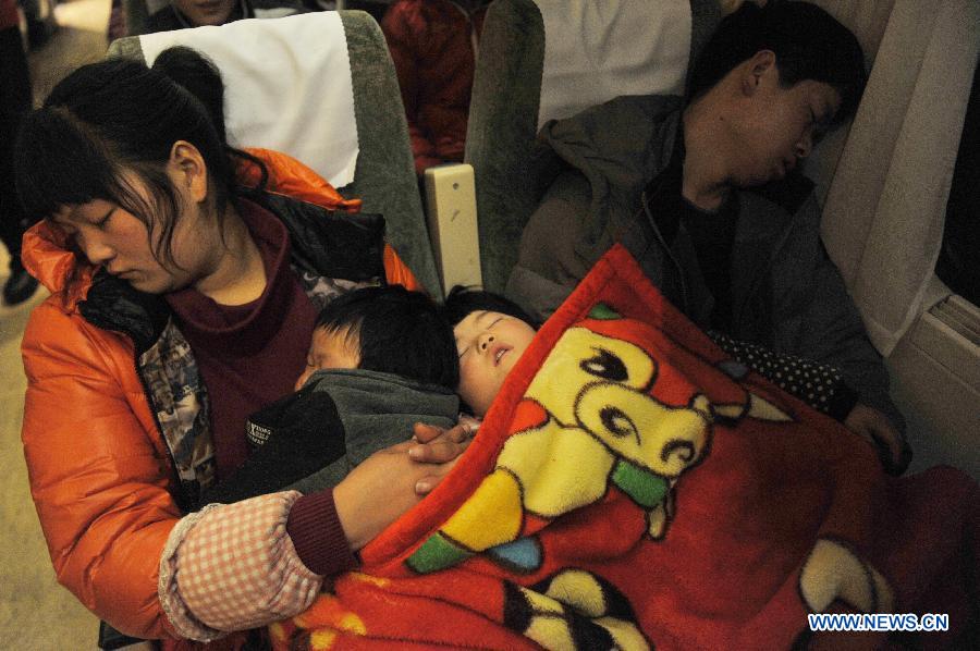 Passengers sleep on the train L8600 from Hangzhou, capital of east China's Zhejiang Province, to Fuyang, east China's Anhui Province, Jan. 29, 2013. The 40-day Spring Festival travel rush started on Jan. 26. The Spring Festival, which falls on Feb. 10 this year, is traditionally the most important holiday of the Chinese people. It is a custom for families to reunite in the holiday, a factor that has led to massive seasonal travel rushes in recent years as more Chinese leave their hometowns to seek work elsewhere. Public transportation is expected to accommodate about 3.41 billion travelers nationwide during the holiday, including 225 million railway passengers.(Xinhua/Huang Zongzhi) 