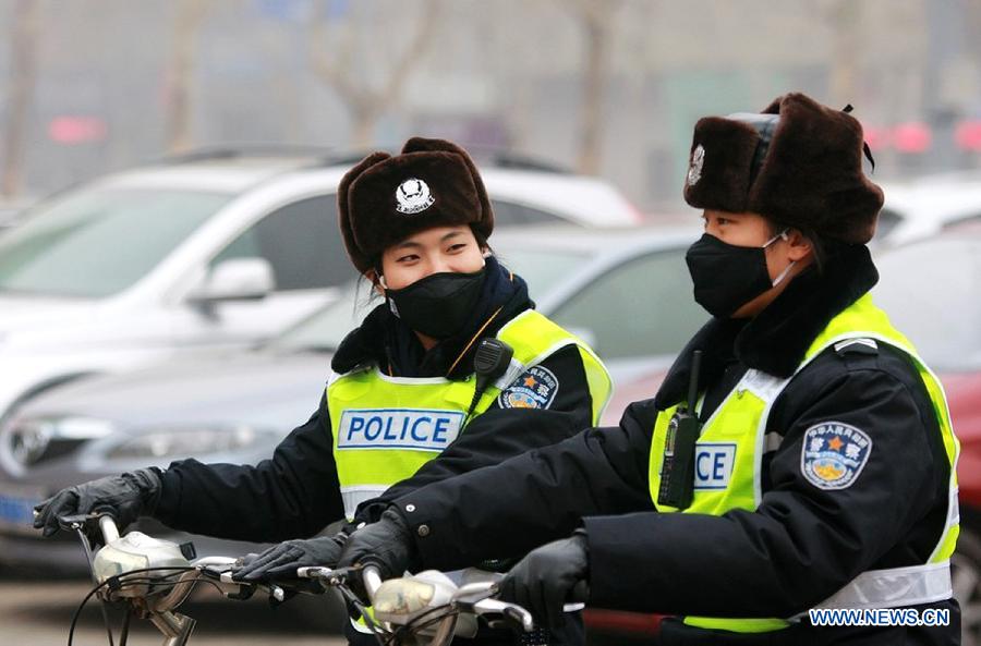 Two traffic policewomen with masks work in Jinan, capital of east China's Shandong Province, Jan. 30, 2013. The local traffic policemen used masks to protect their health in hazy days.(Xinhua/Xu Suhui) 
