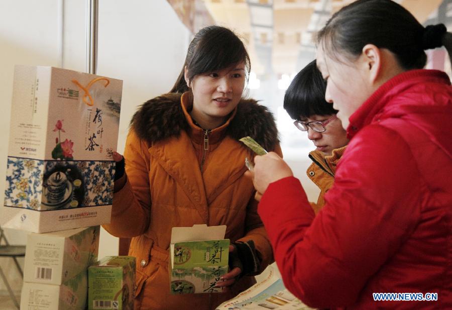 People buy tea in a Chinese new year goods market in Tengzhou, east China's Shandong Province, Jan. 30, 2013. As the spring festival drew near, people began their shopping for the celebration. (Xinhua/Song Haicun)