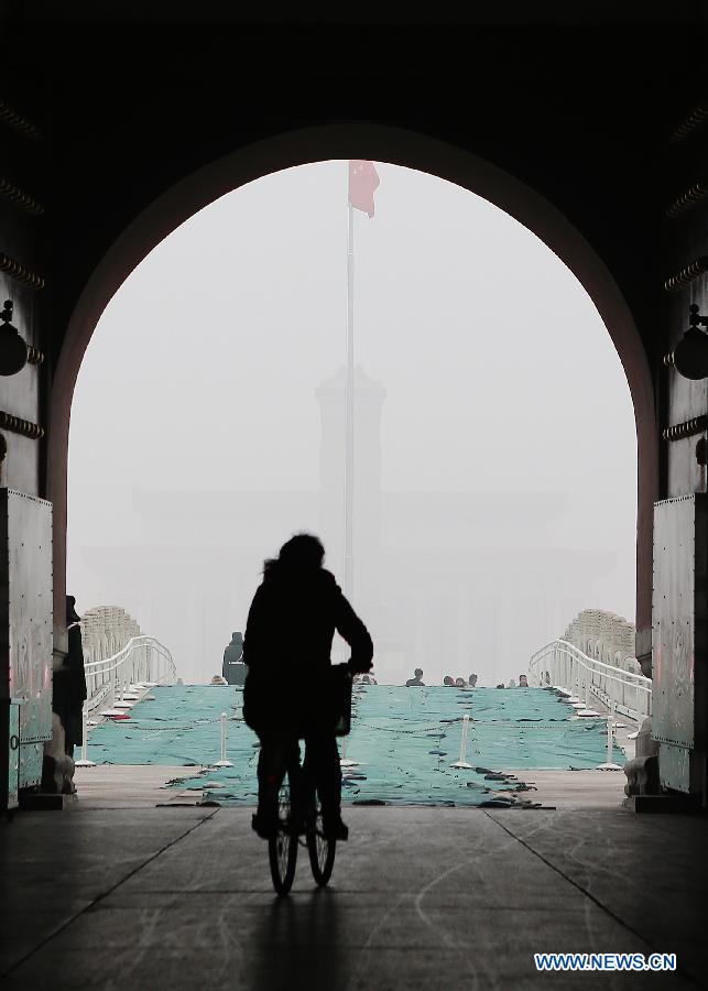A rider is seen under the gate of the Tian'anmen Rostrum in Beijing, capital of China, Jan. 30, 2013. The meteorological observatory in Beijing issued an orange alert and a yellow alert against heavy fog and haze respectively on 6:00 am Wednesday. Heavy fog has been lingering in central and eastern China since Tuesday afternoon, disturbing the traffic. (Xinhua/Li Fangyu) 