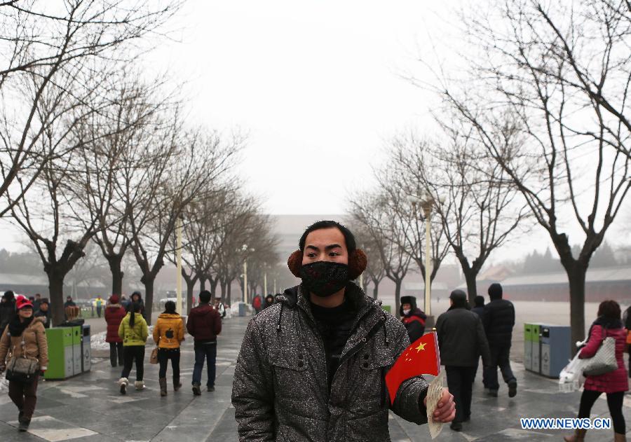 Tourists are seen outside the Forbidden City in Beijing, capital of China, Jan. 30, 2013. The meteorological observatory in Beijing issued an orange alert and a yellow alert against heavy fog and haze respectively on 6:00 am Wednesday. Heavy fog has been lingering in central and eastern China since Tuesday afternoon, disturbing the traffic. (Xinhua/Li Fangyu) 