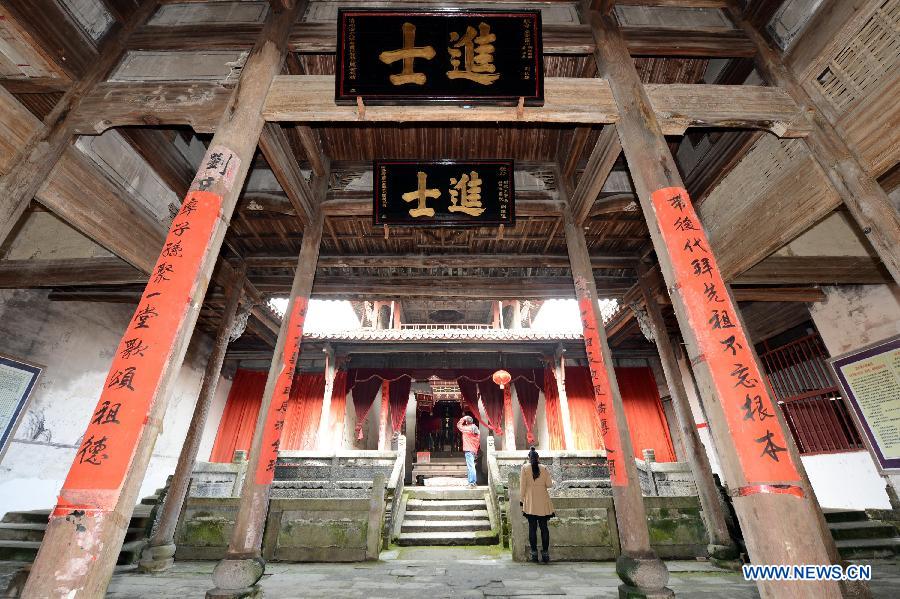 Tourists visit an ancient building in Tianbao Village in Yifeng County, east China's Jiangxi Province, Jan. 30, 2013. Tianbao Village, whose history is about 1,800 years, can date back to the Tang Dynasty (618-907), covering an area of more than 2.5 square kilometers. Tianbao was ever the county site of the ancient Yifeng County, carrying profound cultural connotation. There are more than 120 buildings in the village built in the Ming and Qing dynasties (1368-1912), all of which present high artistic value. The village has been listed in the pool of national cultural and natural heritage protection projects. (Xinhua/Song Zhenping)