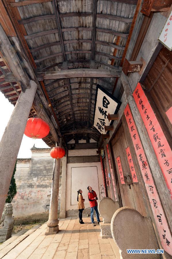 Tourists visit an ancient building in Tianbao Village in Yifeng County, east China's Jiangxi Province, Jan. 30, 2013. Tianbao Village, whose history is about 1,800 years, can date back to the Tang Dynasty (618-907), covering an area of more than 2.5 square kilometers. Tianbao was ever the county site of the ancient Yifeng County, carrying profound cultural connotation. There are more than 120 buildings in the village built in the Ming and Qing dynasties (1368-1912), all of which present high artistic value. The village has been listed in the pool of national cultural and natural heritage protection projects. (Xinhua/Song Zhenping)