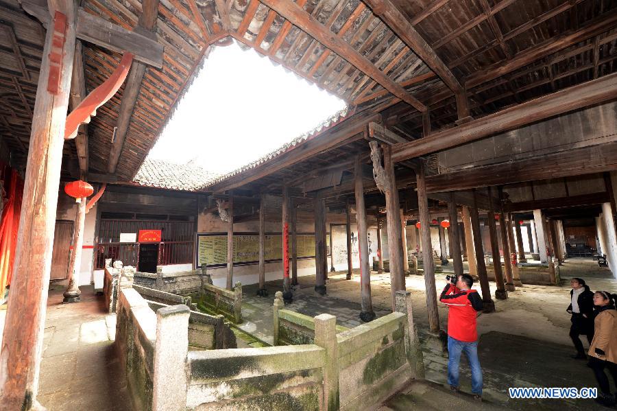 Tourists visit an ancient building in Tianbao Village in Yifeng County, east China's Jiangxi Province, Jan. 30, 2013. Tianbao Village, whose history is about 1,800 years, can date back to the Tang Dynasty (618-907), covering an area of more than 2.5 square kilometers. Tianbao was ever the county site of the ancient Yifeng County, carrying profound cultural connotation. There are more than 120 buildings in the village built in the Ming and Qing dynasties (1368-1912), all of which present high artistic value. The village has been listed in the pool of national cultural and natural heritage protection projects. (Xinhua/Song Zhenping)