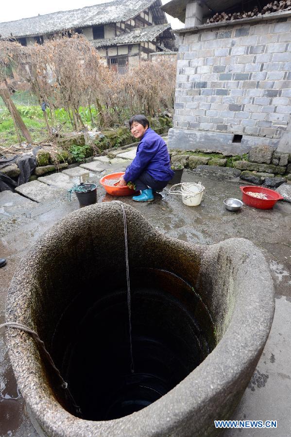 A villager washes clothes near an ancient well in Tianbao Village in Yifeng County, east China's Jiangxi Province, Jan. 30, 2013. Tianbao Village, whose history is about 1,800 years, can date back to the Tang Dynasty (618-907), covering an area of more than 2.5 square kilometers. Tianbao was ever the county site of the ancient Yifeng County, carrying profound cultural connotation. There are more than 120 buildings in the village built in the Ming and Qing dynasties (1368-1912), all of which present high artistic value. The village has been listed in the pool of national cultural and natural heritage protection projects. (Xinhua/Song Zhenping)