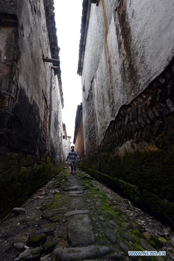 A child runs on an ancient lane in Tianbao Village in Yifeng County, east China's Jiangxi Province, Jan. 30, 2013. Tianbao Village, whose history is about 1,800 years, can date back to the Tang Dynasty (618-907), covering an area of more than 2.5 square kilometers. Tianbao was ever the county site of the ancient Yifeng County, carrying profound cultural connotation. There are more than 120 buildings in the village built in the Ming and Qing dynasties (1368-1912), all of which present high artistic value. The village has been listed in the pool of national cultural and natural heritage protection projects. (Xinhua/Song Zhenping)