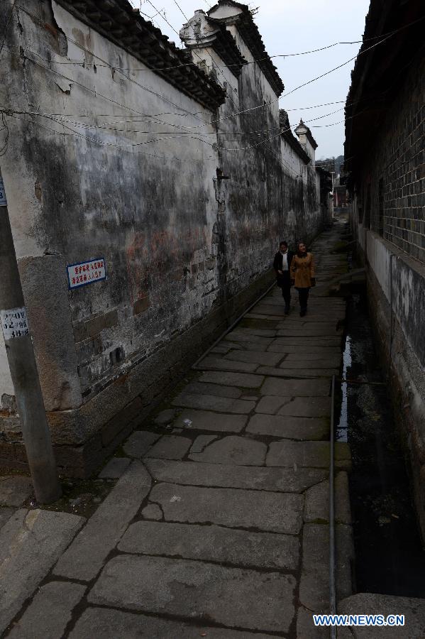 Tourists walk on an ancient lane in Tianbao Village in Yifeng County, east China's Jiangxi Province, Jan. 30, 2013. Tianbao Village, whose history is about 1,800 years, can date back to the Tang Dynasty (618-907), covering an area of more than 2.5 square kilometers. Tianbao was ever the county site of the ancient Yifeng County, carrying profound cultural connotation. There are more than 120 buildings in the village built in the Ming and Qing dynasties (1368-1912), all of which present high artistic value. The village has been listed in the pool of national cultural and natural heritage protection projects. (Xinhua/Song Zhenping)
