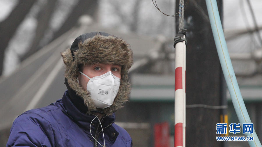 A pedestriant wears a breathing mask outside in the early morning of January 29th, 2013. (Photo/Xinhua)