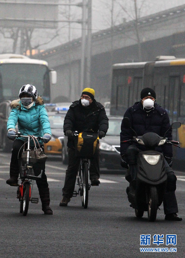 Beijing residents wear a breathing mask outside in the early morning of January 29th, 2013. (Photo/Xinhua)
