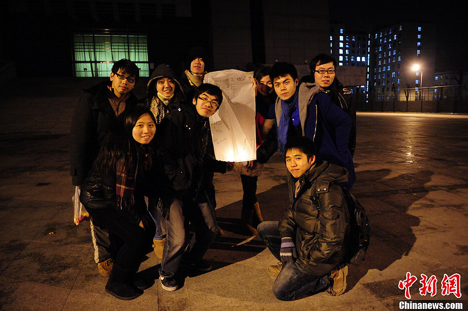 Lin and his friends pose for a picture before flying the lantern. (Chinanews/Cui Nan)