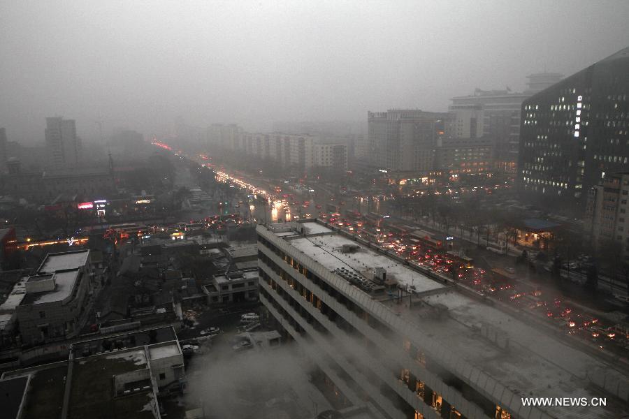 Buildings are smothered by fog in Beijing, capital of China, Jan. 31, 2013. Light snow hit parts of the city on Thursday and the local meteorological observatory issued a yellow alert for icy road. (Xinhua/Jin Liwang) 
