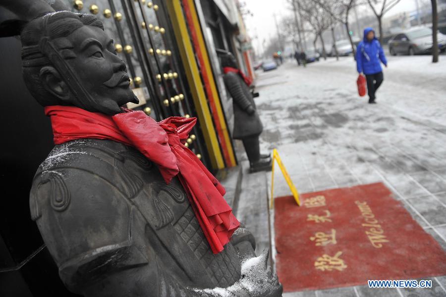 Photo taken on Jan. 31, 2013 shows a Terra Cotta Warriors model covered with snow in Beijing, capital of China. Snow hit parts of the city on Thursday and the local meteorological observatory issued the yellow alert for icy road. (Xinhua/Lu Peng)
