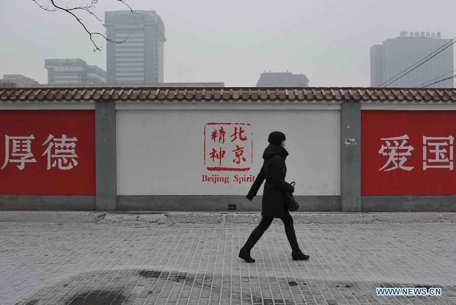 A woman walks on a icy road near the Lugu Street of Shijingshan District in Beijing, capital of China, Jan. 31, 2013. Snow hit parts of the city on Thursday and the local meteorological observatory issued the yellow alert for icy road. (Xinhua/Lu Peng) 