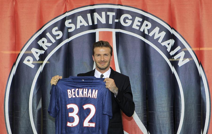 Soccer player David Beckham (R) presents his new jersey after a news conference in Paris January 31, 2013. (Photo: Xinhua/Reuters)