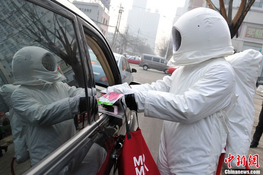 A man dressed as an astronaut hands out free masks on a street in Taiyuan of Shanxi Province- one of China’s coal mine hubs-on Jan 31, 2013 (Photo/CNS)