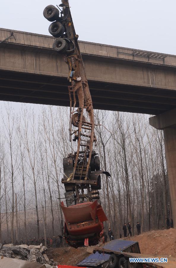 Photo taken on Feb. 1, 2013 shows a demolished truck hanging at the accident locale where an 80 meter-long section of an expressway bridge collapsed due to a truck explosion in Mianchi County of Sanmenxia City in central China's Henan Province.  (Xinhua/Zhao Peng)