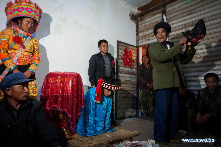 Bride Gu Hongyan (2nd L, back) and bridegroom Lan Xiaoxiang (3rd L, back) attends a traditional wedding ceremony of Lisu ethnic group in Xinyu Village of Dechang County, southwest China's Sichuan Province, Jan. 31, 2013. (Xinhua/Jiang Hongjing)