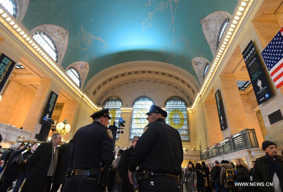 Policmen guard as commuters walk inside Grand Central Terminal in New York on Feb. 1, 2013. Grand Central Terminal, the New York city's landmark, turned 100 years old on Friday. (Xinhua/Wang Lei)