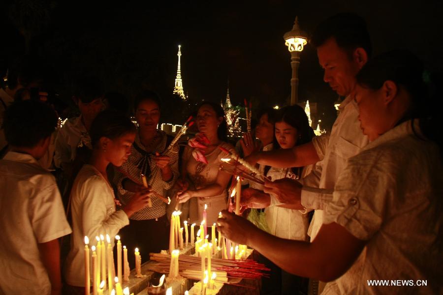 People light candles and incense sticks to pray for the late Cambodian King Father Norodom Sihanouk in Phnom Penh, Cambodia, Feb. 1, 2013. The body of late King Father Norodom Sihanouk was carried from the Palace in a procession to a custom-built crematorium at the Veal Preah Meru Square next to the Palace on Friday. The body will be kept for another three days and then will be cremated on Feb. 4. (Xinhua/Sovannara)