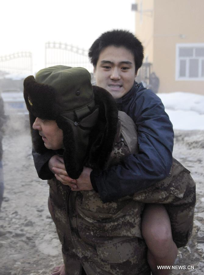 A rescuer transfers a trapped citizen of a dyke breaching accident of the Lianfeng Reservoir in Urumqi, capital of northwest China's Xinjiang Uygur Autonomous Region, Feb. 2, 2013. At least one person was killed and serveral injured after a dyke breaching occured at the reservior on the morning of Saturday. The rescue work is underway. (Xinhua/Zhao Ge) 