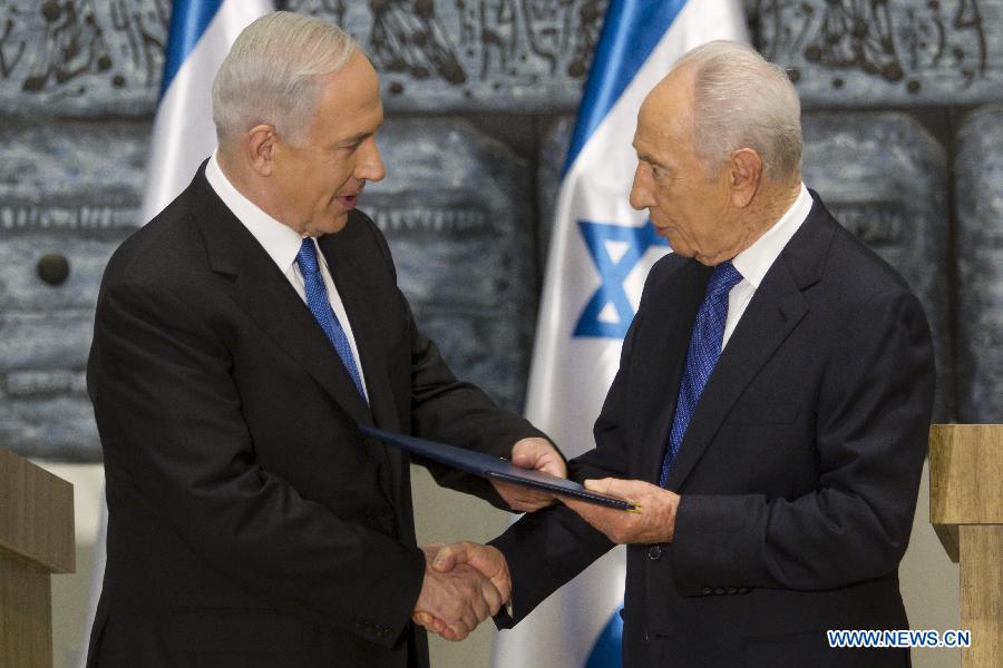 Israeli Prime Minister Benjamin Netanyahu (L) receives a folder from Israeli President Shimon Peres at the conclusion of a brief ceremony in the president' Jerusalem residence, Feb. 2, 2013. Israeli President Shimon Peres tasked incumbent Prime Minister Benjamin Netanyahu on Saturday evening with the task of forming a new government, amid the results of the Jan. 22 national elections. (Xinhua/pool/Jim Hollander)