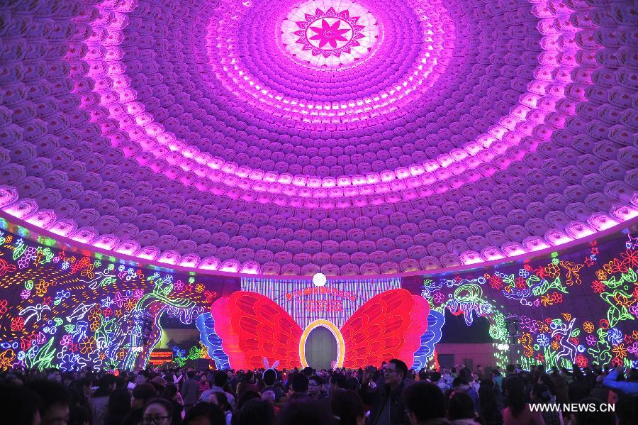 Visitors are seen under a dome decorated with lanterns on a preview of the 19th Zigong International Dinosaur Lantern Festival in Zigong, southwest China's Sichuan Province, Feb. 2, 2013. The lantern festival is scheduled to be held here to celebrate the Chinese Lunar New Year. (Xinhua/Lu Peng) 