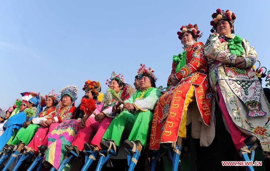 Performers of a local art troupe prepare to perform stilts dance during a festive activity or "Shehuo" in Chinese at a temple fair in Huaiyang County, central China's Henan Province, March 18, 2010. Festive activity is an ancient form of folk art, a popular comprehensive cultural activity held during the Spring Festival or Chinese Lunar New Year among people. (Xinhua/Wang Song)
