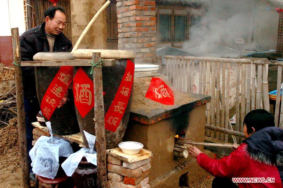 Villagers brew rice wine with traditional technique at a yard in Zhengzhou, capital of central China's Henan Province, Jan. 28, 2006. People in many villages in central China region still follow the custom to brew rice wine by themselves beforehand so as to drink the wine on the Chinese New Year's eve. Chinese people who live in the central China region have formed various traditions to celebrate the Chinese Lunar New Year. (Xinhua/Wang Song)