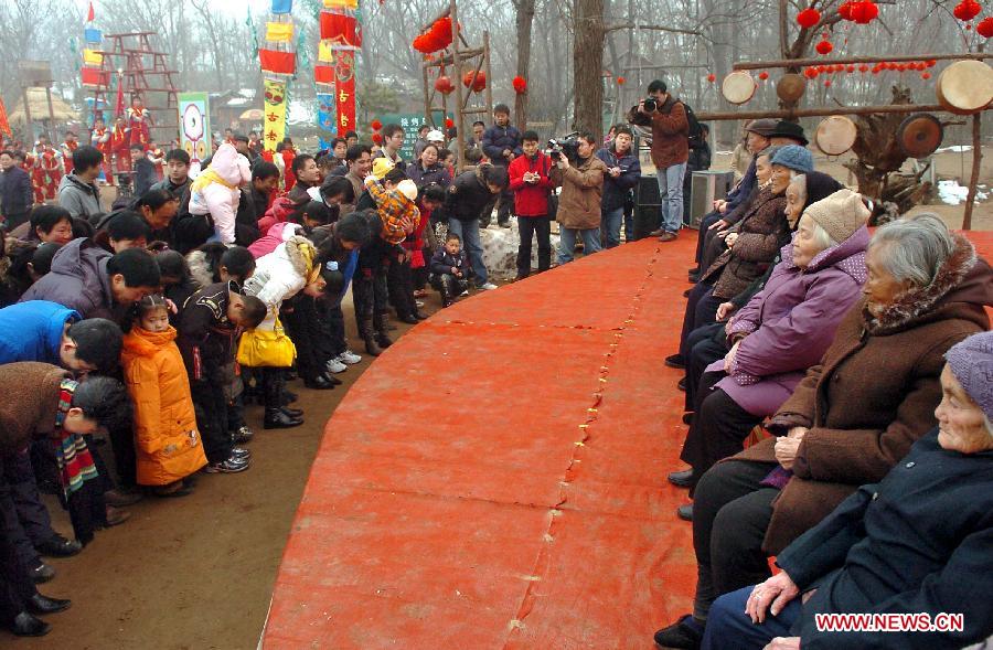 Younger generation bow to their elders to extend their Spring Festival greetings at a temple fair in Zhengzhou, capital of central China's Henan Province, Jan. 28, 2006. It is a custom for younger generation to pay New Year call to elders during the Spring Festival. The elderly, in return, would give the young Yasui money meaning "money waring off evil spirits."