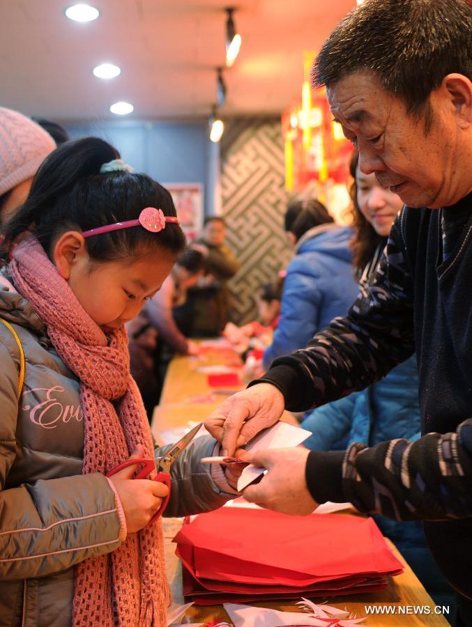 Citizens learn to make paper-cuttings at the Hebei Folk Arts Museum in Shijiazhuang, capital of north China's Hebei Province, Feb. 3, 2013. Pupils of Weitong Primary School were invited on Feb. 3 to present paper-cuttings at the museum to greet the upcoming Spring Festival, which falls on Feb. 10 this year. (Xinhua/Zhu Xudong) 