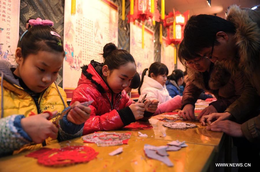 Citizens learn to paper-cuttings at the Hebei Folk Arts Museum in Shijiazhuang, capital of north China's Hebei Province, Feb. 3, 2013. Pupils of Weitong Primary School were invited on Feb. 3 to present paper-cuttings at the museum to greet the upcoming Spring Festival, which falls on Feb. 10 this year. (Xinhua/Zhu Xudong)