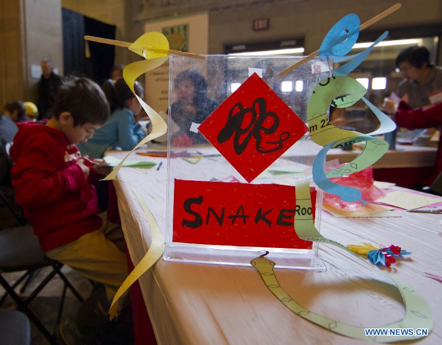 Kids learn to cut a paper snake during the Chinese Cultural Heritage Day event at the Royal Ontario Museum in Toronto, Canada, Feb. 2, 2013. One of the most prominent museums in the Canadian city of Toronto was transformed into a galore of Chinese artistry on Saturday, presenting a live snake display, an ethnic costume display and a diverse array of Chinese-themed performances. (Xinhua/Zou Zheng)