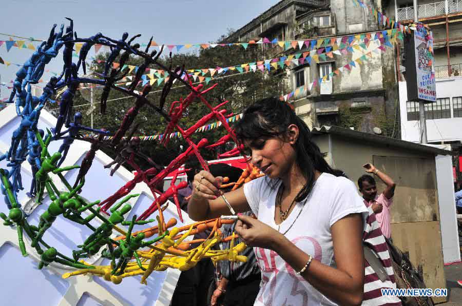 An artist paints color for her work during the 15th Kala Ghoda Arts Festival held in Mumbai, India, on Feb. 2, 2013. The 15th Kala Ghoda Arts Festival kicked off here on Saturday, lasting until Feb. 10.(Xinhua/Wang Ping)