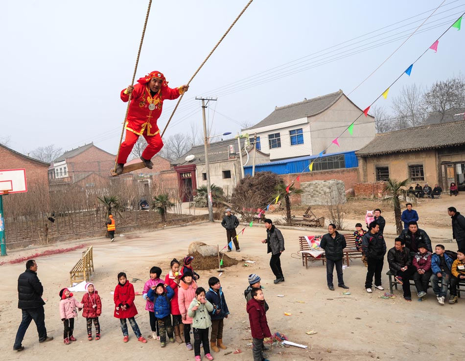 A villager in ancient costume plays on the swing in Shangyanghua village of Shaanxi province on Jan. 31, 2013. It's an ancient local custom to welcome the Spring Festival. (Xinhua/Ding Haitao) 