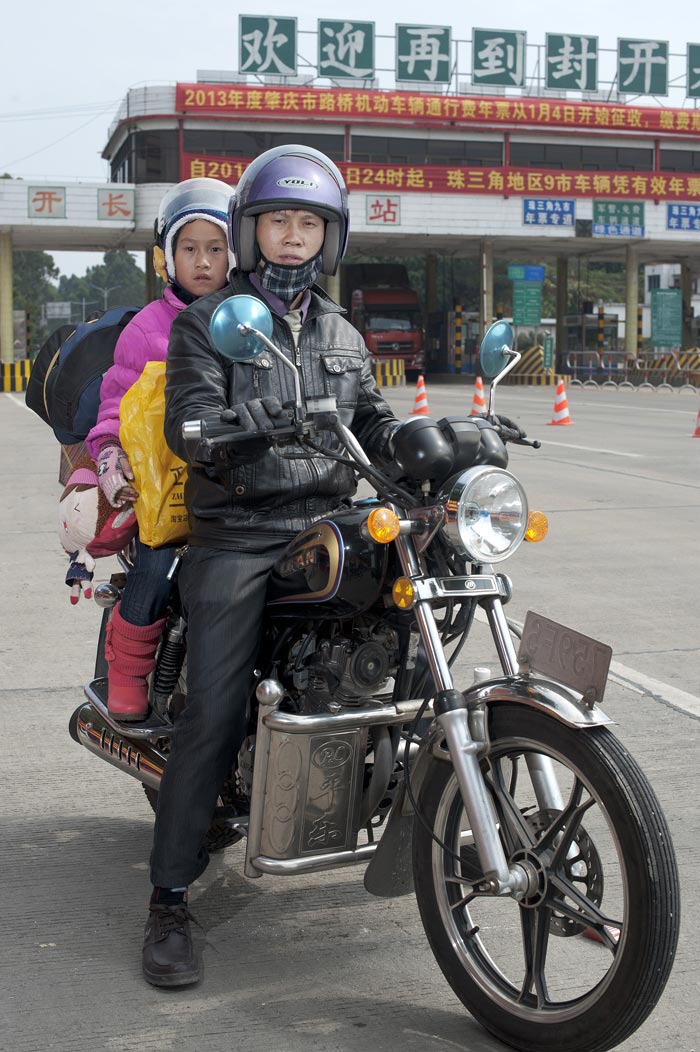 Tan shunjie (left) and his daughter Tan Shishi travel on motorcycle from Jiangmen city of Guangdong province to Wuxuan county of Guangxi, their hometown, Jan. 30, 2013. (Xinhua/Wu Lu) 