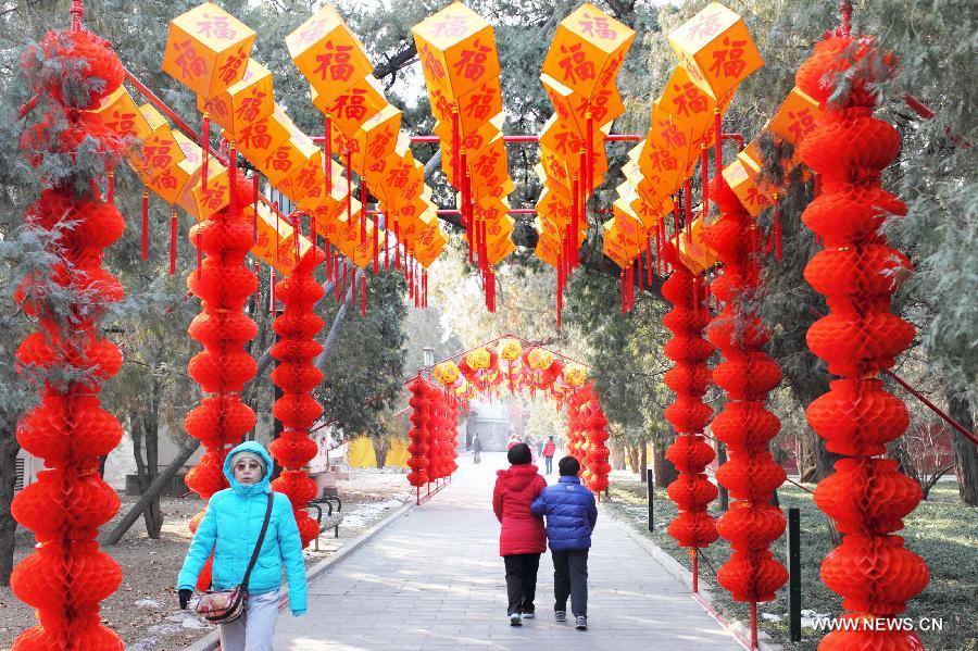 Tourists walk along a corridor decorated with red lanterns in the Temple of Earth Park in Beijing, capital of China, Feb. 2, 2013. The Temple of Earth Park was decorated with red lanterns so as to celebrate the upcoming Spring Festival or Chinese Lunar New Year. (Xinhua)