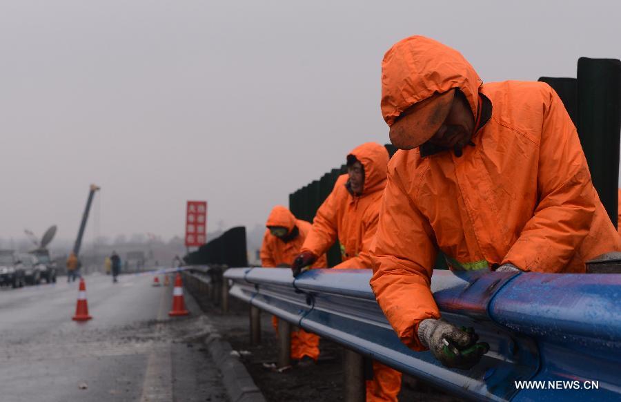 Workers repair guardrails of a collapsed viaduct in Mianchi County, Sanmenxia City, central China's Henan Province, Feb. 3, 2013. A part of the expressway viaduct collapsed on Friday morning when an explosion caused by a truck loaded with fireworks took place. Ten people died and 11 others were injured in the accident. Local transportation authority conducted a safety evaluation on the viaduct with vehicle restrictions. (Xinhua/Zhao Peng)