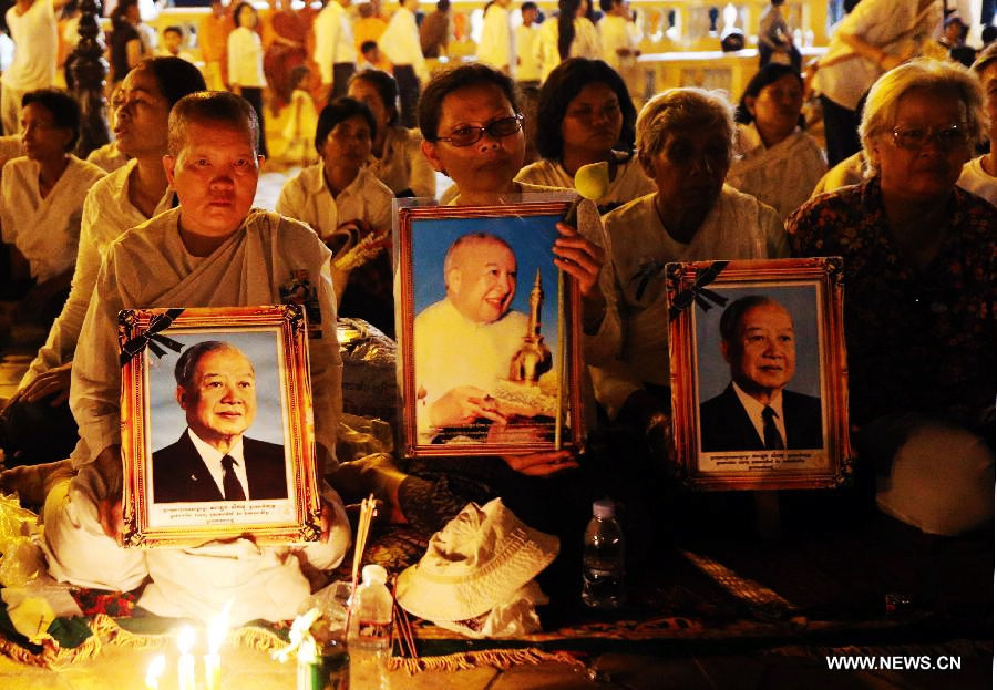 People sit to pay their respects to the late former king Norodom Sihanouk in front of the Royal Palace in Phnom Penh, capital of Cambodia, on Feb. 3, 2013. The royal cremation ceremony of the late former Cambodian King Norodom Sihanouk will be held on Monday. (Xinhua/Yao Dawei)
