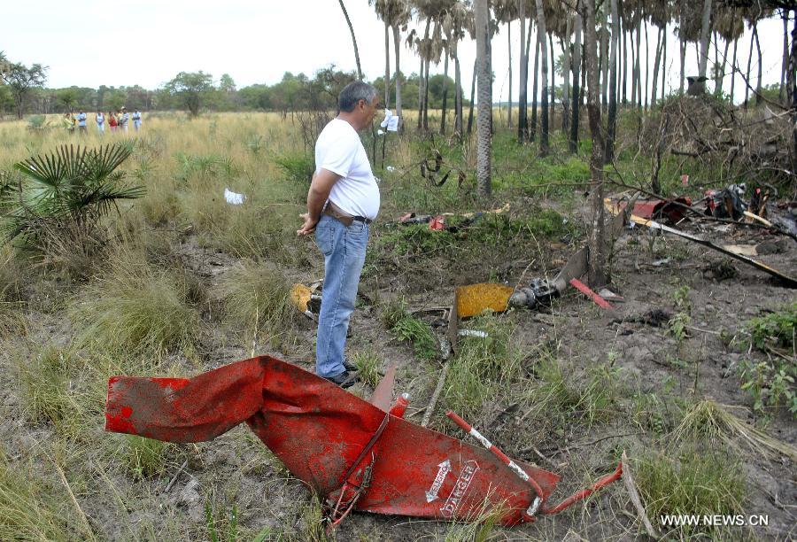 A man stands near the debris of the helicopter that transported former army chief and presidential candidate Lino Cesar Oviedo, near Puerto Antequera, Paraguay, on Feb. 3, 2013. Paraguayan presidential candidate Lino Cesar Oviedo was killed when a helicopter carrying him crashed in northern Paraguay late Saturday, said reports from Asuncion on Sunday. (Xinhua/Diario Abc Color)