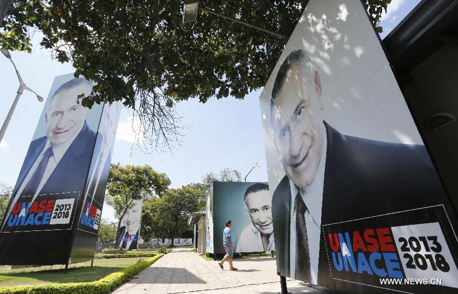 A man walks past portraits of retired general and presidential candidate Lino Cesar Oviedo in Asuncion, capital of Paraguay, on Feb. 3, 2013. Lino Oviedo, who helped topple Paraguayan dictator Alfredo Stroessner in 1989, died with two other victims in a helicopter crash Saturday night near Puerto Antequera on their way back to the capital after taking part in a campaign rally. (Xinhua/Rene Gonzalez)
