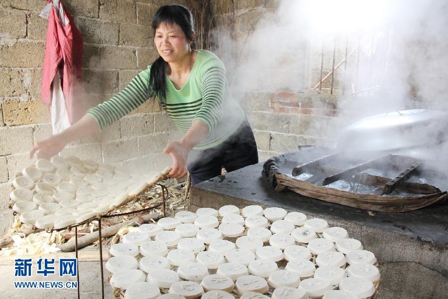 A women steams rice cakes for the coming Spring Festival in Guangxi. Rice cake is made of glutinous rice powder as main material, seasoned with peanut, sesame and sugar then steam in high temperature. (Xinhua/ Chen Dongmei)