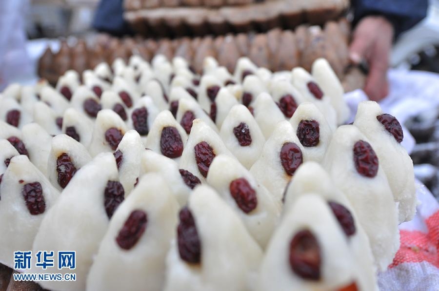 Photo shows the rice cakes made by people on Xiaonian, the 23th day of the 12th month on lunar calendar, in Shandong province. Local people use wheat or glutinous rice to make the cakes and dressing with dates on the top. (Xinhua/ Dong Naide)